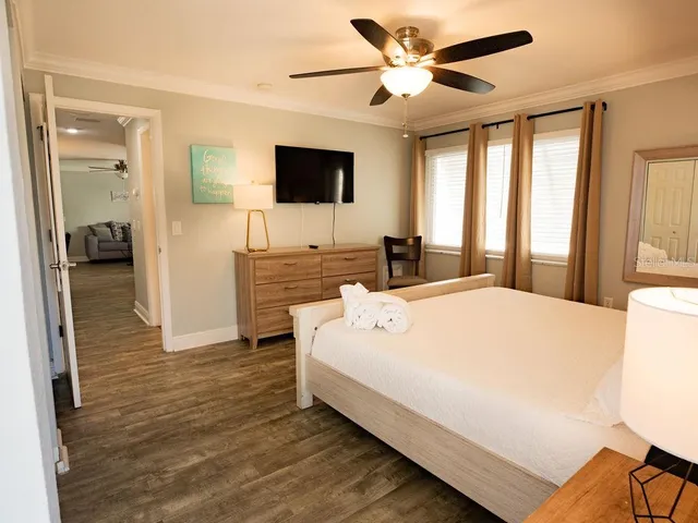 a spacious bedroom with a bed and a flat screen tv