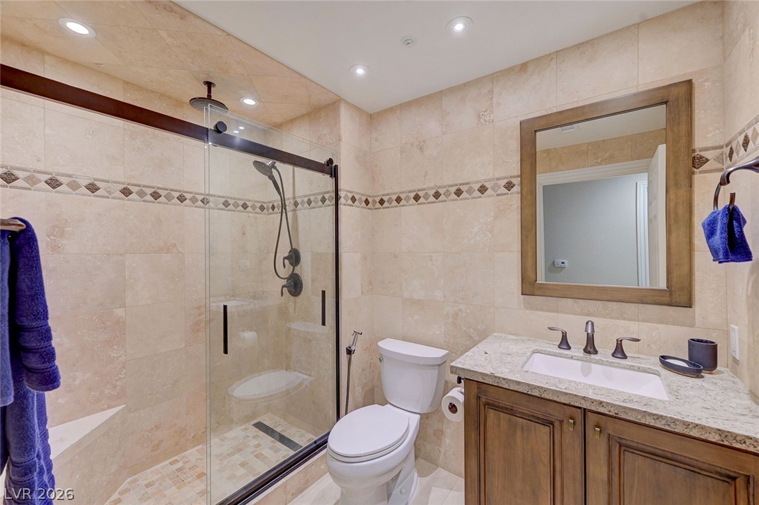 230 East Flamingo Road, Unit 106 Las Vegas, NV 89169 - Photo 20 of 66 Luxurious tile work and modern fixtures define this pristine primary bathroom.