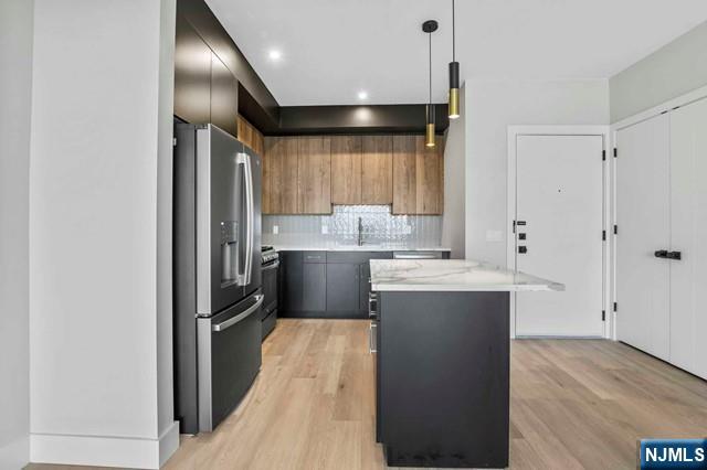 a kitchen with kitchen island a sink stainless steel appliances and cabinets