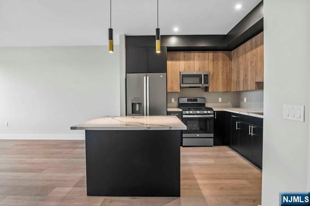 2021 Jones Road, Unit 203 Fort Lee, NJ 07024 - Photo 3 of 10 a kitchen with stainless steel appliances granite countertop a stove a refrigerator and a microwave