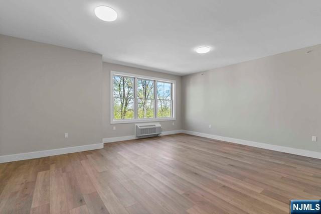 2021 Jones Road, Unit 203 Fort Lee, NJ 07024 - Photo 4 of 10 an empty room with wooden floor and windows