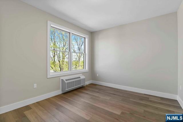 2021 Jones Road, Unit 203 Fort Lee, NJ 07024 - Photo 5 of 10 an empty room with wooden floor and windows