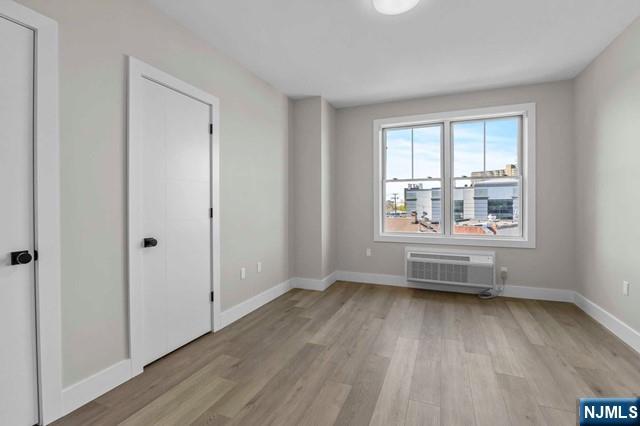2021 Jones Road, Unit 203 Fort Lee, NJ 07024 - Photo 8 of 10 an empty room with wooden floor and windows