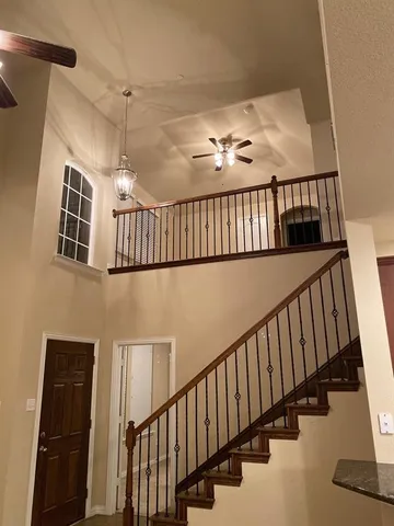 a view of staircase with lots of frames on wall and a window