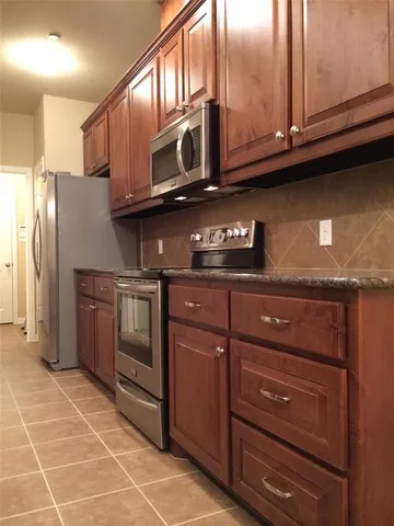a kitchen with stainless steel appliances granite countertop a refrigerator and a stove