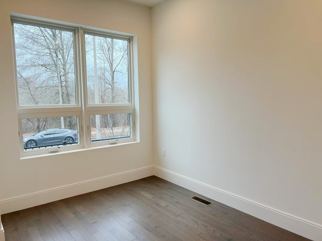23 Charles Park Road, Unit 23 Boston, MA 02132 - Photo 14 of 35 a view of an empty room with wooden floor and a window
