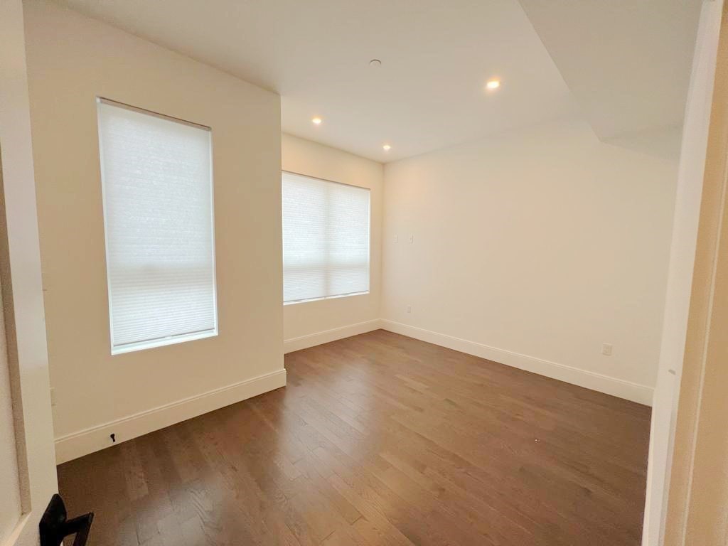 23 Charles Park Road, Unit 23 Boston, MA 02132 - Photo 16 of 35 an empty room with wooden floor and windows