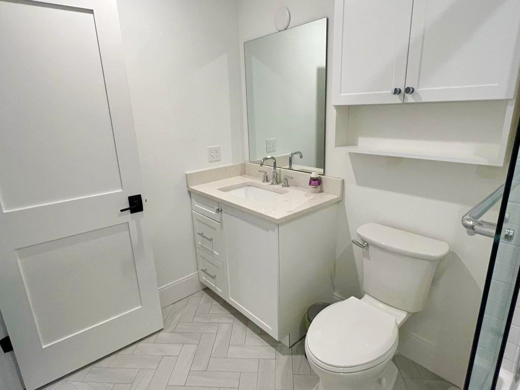 23 Charles Park Road, Unit 23 Boston, MA 02132 - Photo 21 of 35 a bathroom with a toilet sink and a mirror