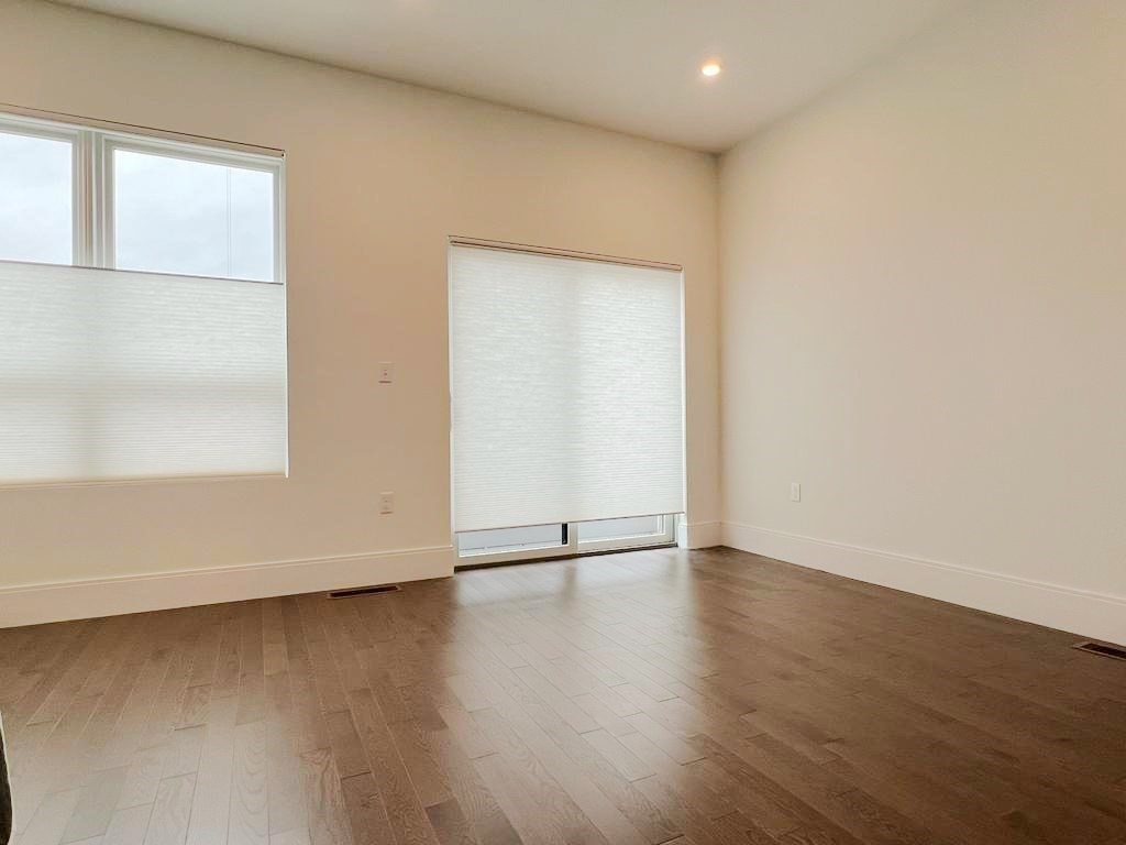 23 Charles Park Road, Unit 23 Boston, MA 02132 - Photo 25 of 35 an empty room with wooden floor and windows