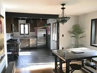 a kitchen with a table chairs refrigerator and stove