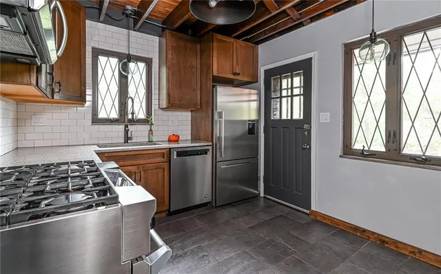 a kitchen with a stove a refrigerator and a window