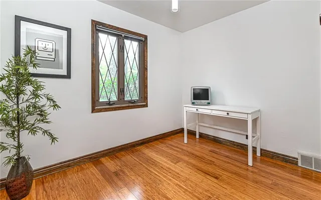 a view of a workspace with furniture and a window