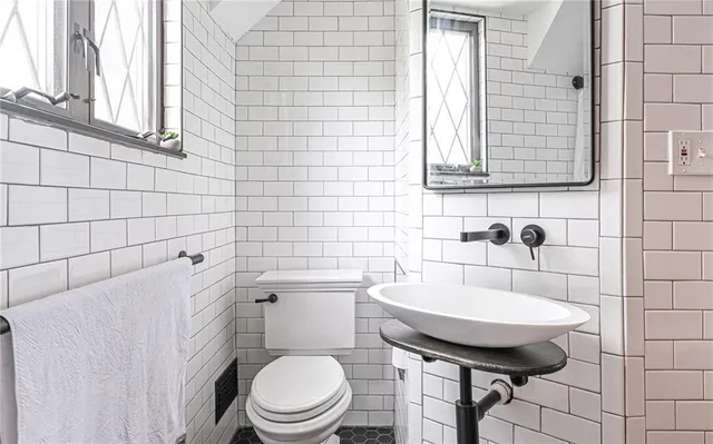 a bathroom with a sink a toilet and mirror