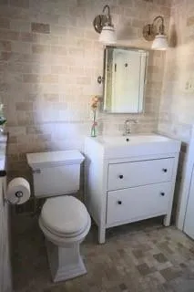 a bathroom with a toilet sink and mirror