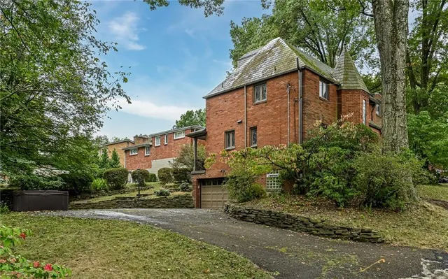 a front view of a house with a yard and tree