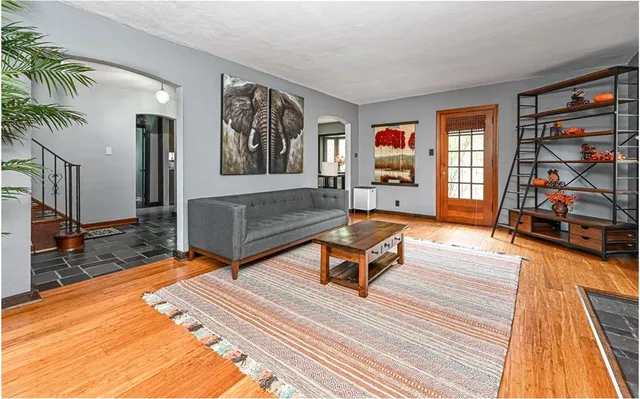 a living room with furniture a rug and a bookshelf