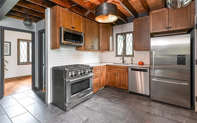 a kitchen with stainless steel appliances granite countertop a refrigerator a stove top oven a sink and dishwasher