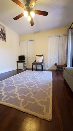 a spacious bedroom with a bed and a chandelier