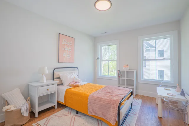 a bedroom with a bed and wooden floor