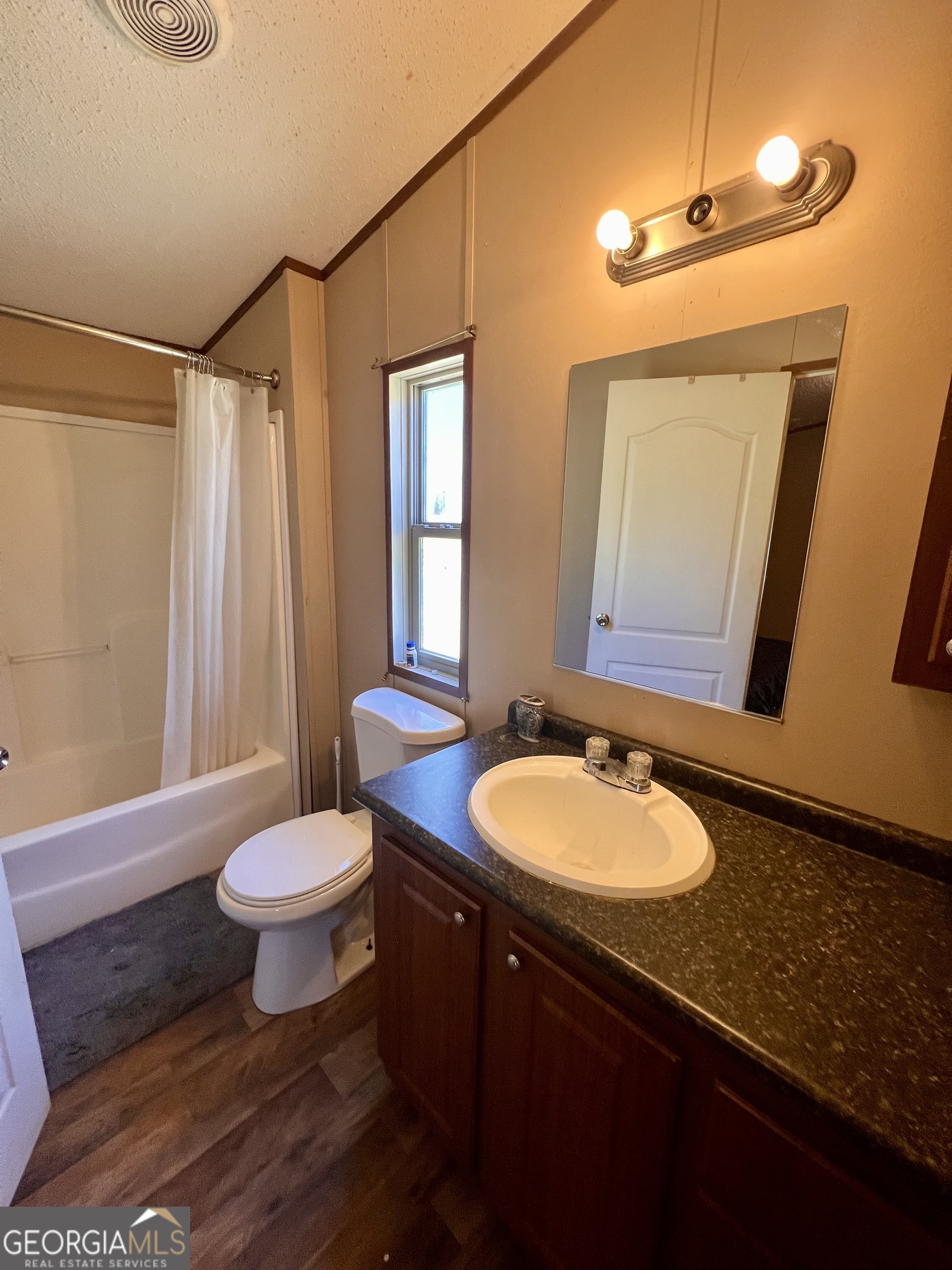 113 Riverview Soperton, GA 30457 - Photo 10 of 16 a bathroom with a granite countertop sink toilet a mirror and shower
