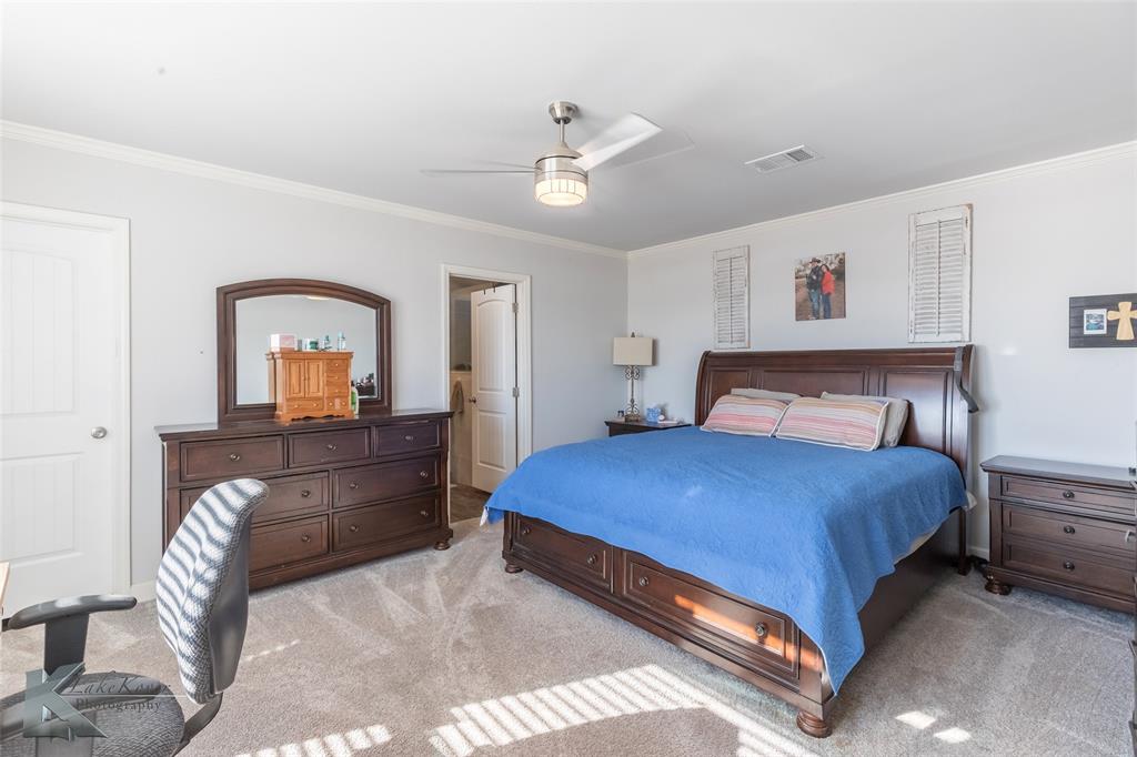 11682 County Road 434 Merkel, TX 79536 - Photo 17 of 37 a bedroom with a large bed and a chandelier