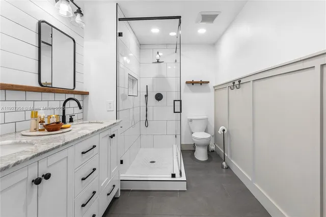 a bathroom with a double vanity sink toilet and shower
