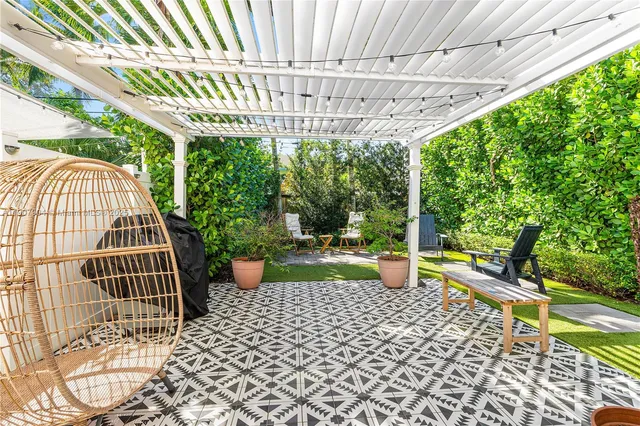 a view of a patio with a table and chairs and potted plants