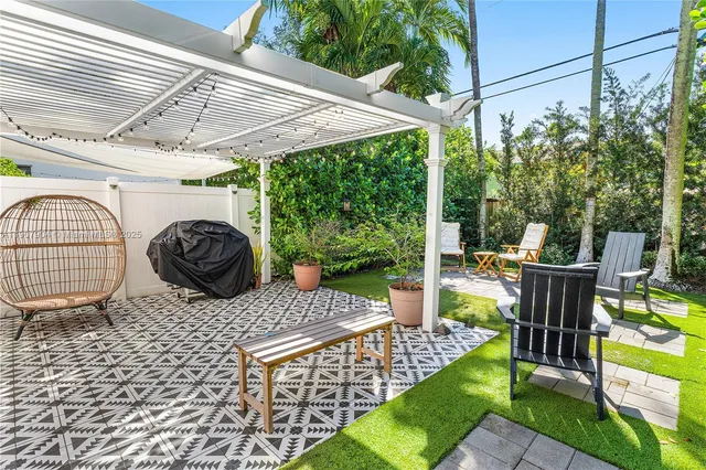 a view of a patio with table and chairs potted plants with wooden floor and fence