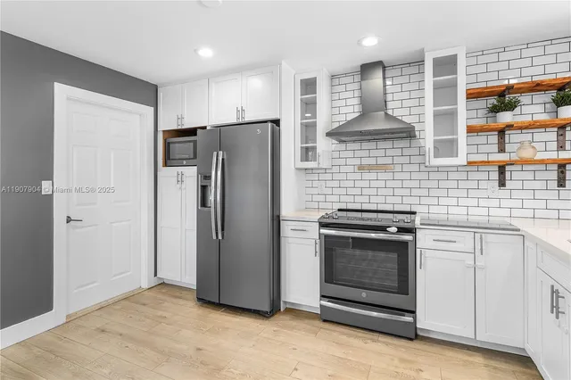 a kitchen with stainless steel appliances granite countertop a refrigerator and a sink