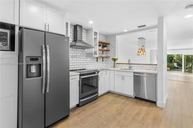 a kitchen with stainless steel appliances a refrigerator sink and microwave