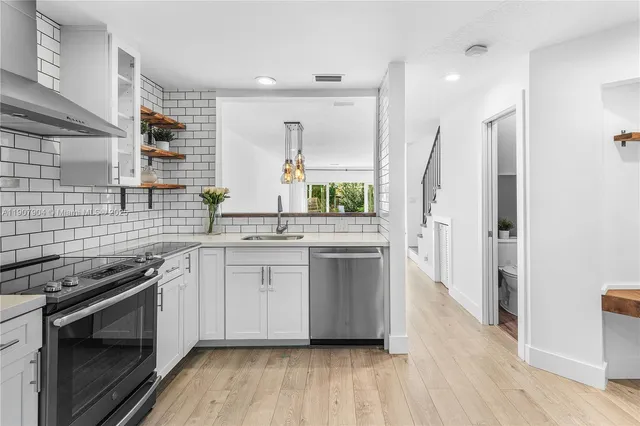 a kitchen with stainless steel appliances a stove sink and refrigerator
