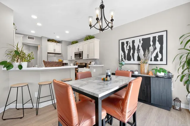 a kitchen with a dining table chairs and refrigerator