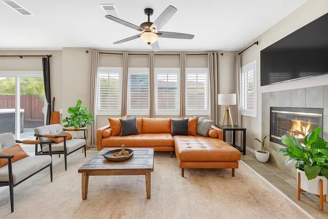 a living room with furniture a flat screen tv and a large window