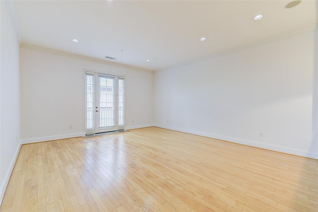 7134 Mapleridge Street, Unit 3B Houston, TX 77081 - Photo 13 of 26 a view of an empty room with wooden floor and a window