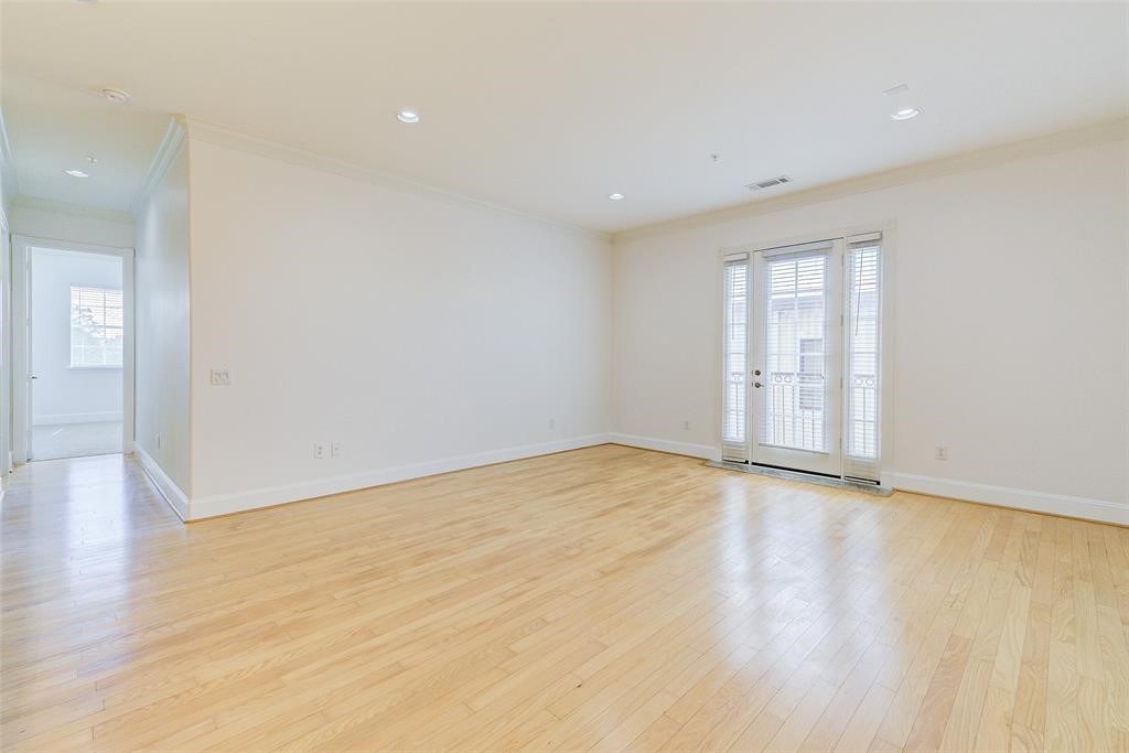 7134 Mapleridge Street, Unit 3B Houston, TX 77081 - Photo 14 of 26 an empty room with wooden floor and windows