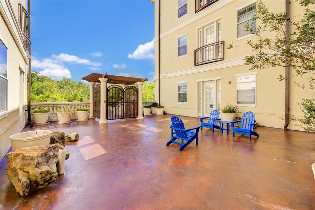 7134 Mapleridge Street, Unit 3B Houston, TX 77081 - Photo 3 of 26 a view of a patio with dining table and chairs under an umbrella with wooden floor