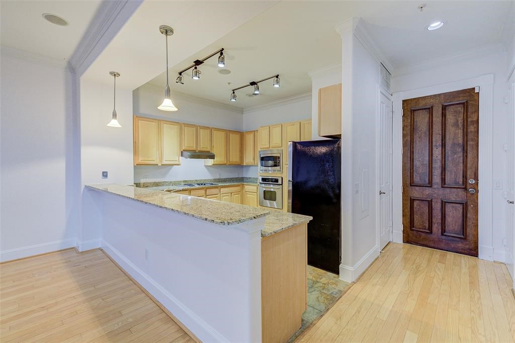 7134 Mapleridge Street, Unit 3B Houston, TX 77081 - Photo 6 of 26 a kitchen with kitchen island a counter top space cabinets and stainless steel appliances
