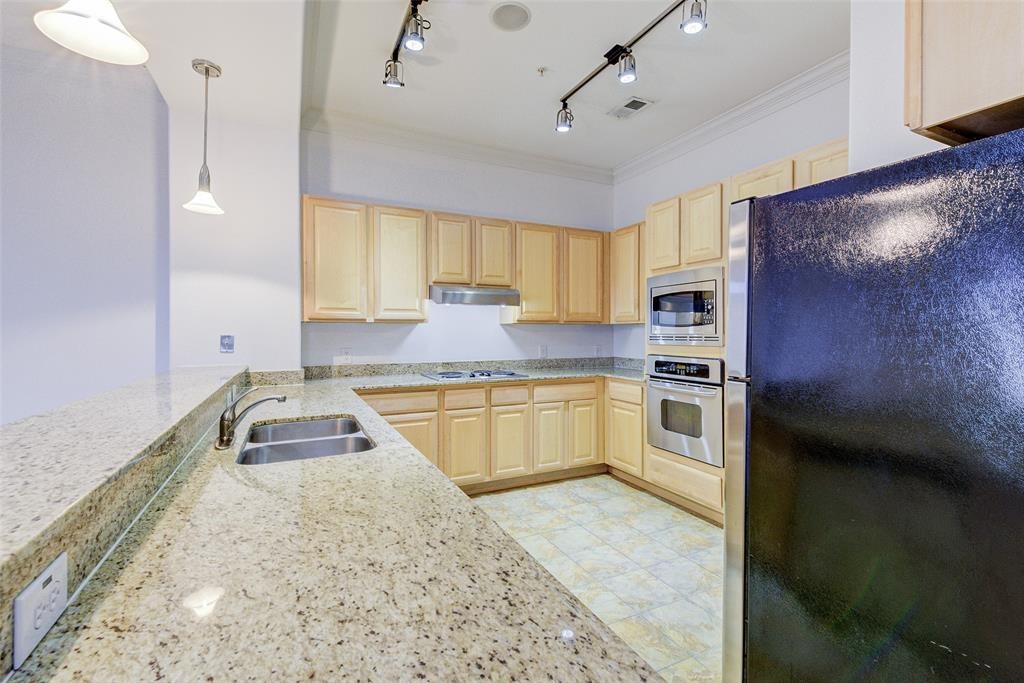 7134 Mapleridge Street, Unit 3B Houston, TX 77081 - Photo 10 of 26 a kitchen with stainless steel appliances granite countertop a sink a stove and a refrigerator