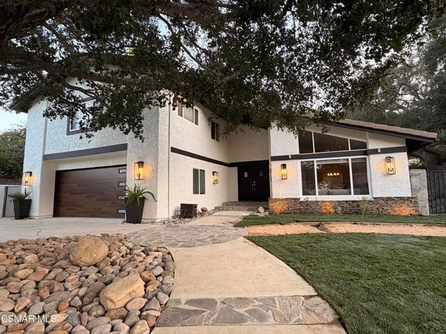 a front view of a house with a yard covered in snow