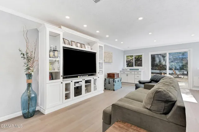 a dining room with furniture a chandelier and wooden floor