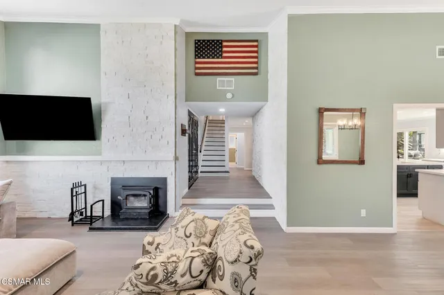 a work room with furniture a rug and a window