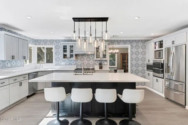 a kitchen with stainless steel appliances granite countertop a sink stove and cabinets