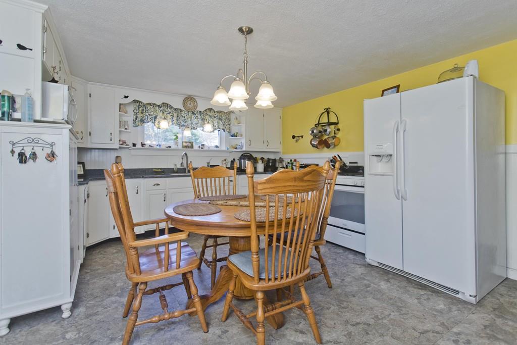 401 Palmer Road Ware, MA 01082 - Photo 14 of 34 a dining room with furniture a chandelier and wooden floor