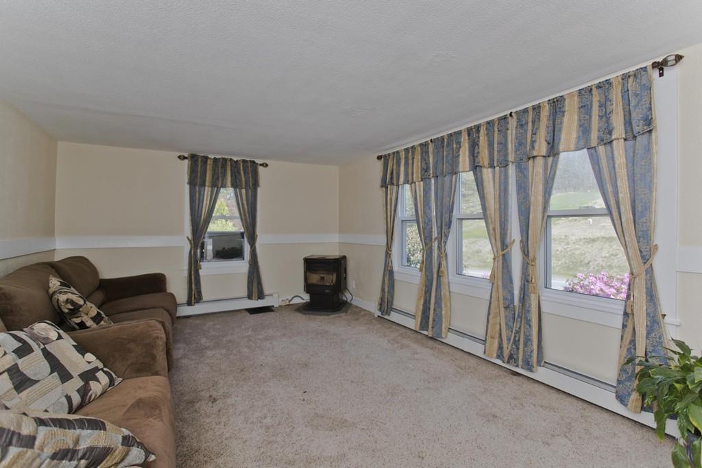 401 Palmer Road Ware, MA 01082 - Photo 21 of 34 a living room with furniture a fireplace and a floor to ceiling window
