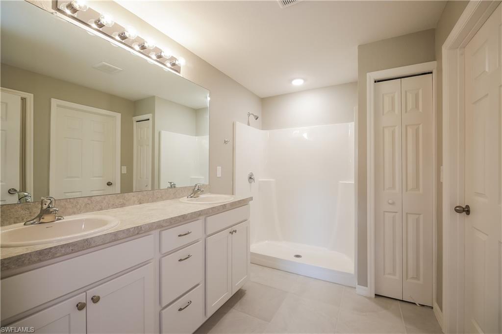 1218 Beaver Street East Lehigh Acres, FL 33974 - Photo 12 of 15 a spacious bathroom with a granite countertop sink a mirror and a