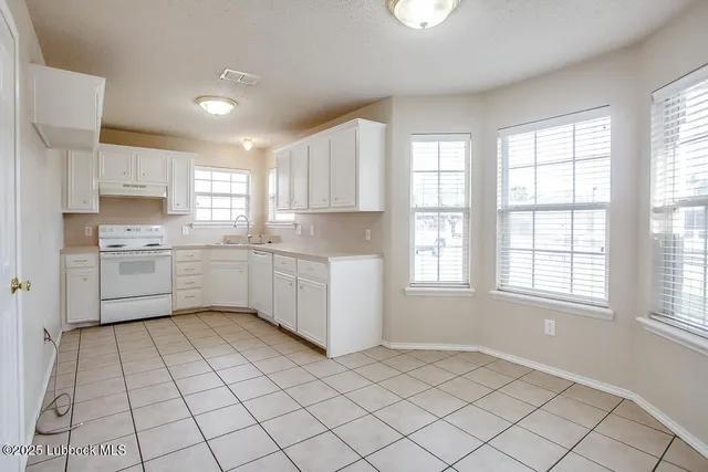 a kitchen with stainless steel appliances a sink window and cabinets
