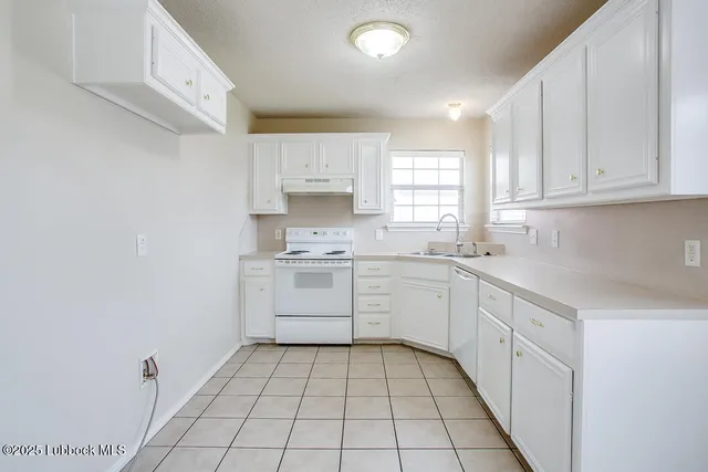 a kitchen with white cabinets and white appliances