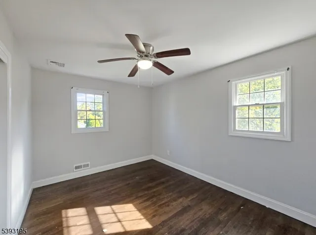 a view of a big room with wooden floor and windows in a room