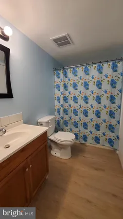 a bathroom with a granite countertop toilet a sink and a mirror