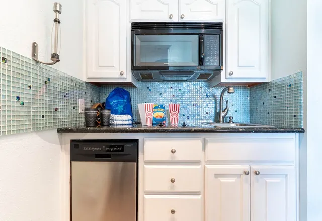 a kitchen with stainless steel appliances granite countertop a sink a stove and cabinets